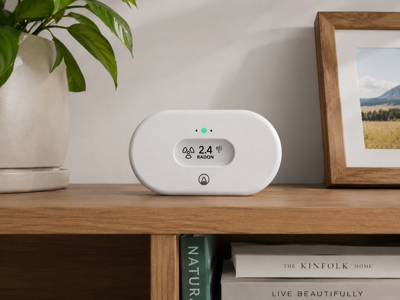 View Radon monitor on a wooden shelf showing a 2.4 pCi/L reading with a green status light
